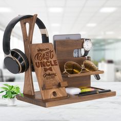 a wooden stand with headphones, sunglasses and other items on it in an office setting