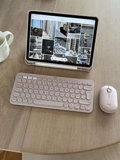 a tablet computer sitting on top of a wooden table next to a keyboard and mouse