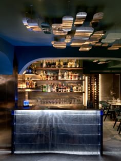 a dimly lit bar with lots of bottles on the shelves and lights hanging from the ceiling