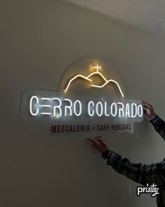 a man standing in front of a sign that says cerro colorado with a cross on it