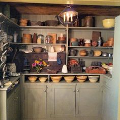 an old fashioned kitchen with lots of pots and pans on the shelves in it