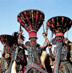 some people are wearing colorful costumes and headdresses while holding their hands up in the air