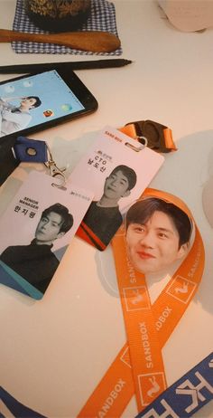 an orange lanyard with a photo of a man on it next to other items