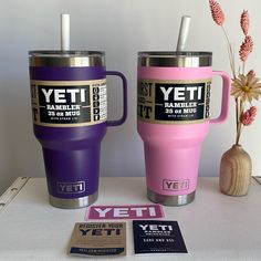 two yeti travel mugs sitting next to each other on top of a table