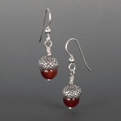 Acorn Earrings,Sterling Silver Jewelry, Carnelian, 1 3/8" x 3/8", HookThese acorn earrings have a cast silver cap, embracing a translucent carnelian bead. This harbinger of fall is the perfect accent when frost is in the air. Acorns are symbols of strength, generosity and hospitality. 277AH>Matching necklace is available.>Also available in white & black pearl>All hook earrings come with rubber safety sleeves Copyright Judie GummPLEASE NOTE:  On international orders, any additional customs duty, Acorn Caps, Acorn Earrings, Acorn Necklace, Tree Earrings, Symbols Of Strength, Silver Caps, Carnelian Beads, Silver Pin, Jewelry Card