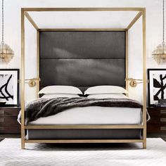 a bed with a black and white blanket on it's headboard in a bedroom