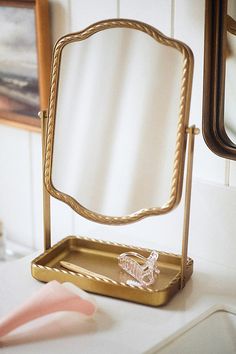 a mirror sitting on top of a table next to a toothbrush