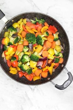 a pan filled with vegetables on top of a white counter