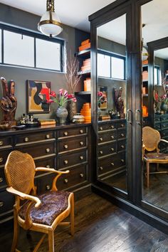 a room that has many drawers and chairs in it, with mirrors on the wall