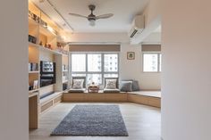 a living room filled with furniture and a flat screen tv on top of a wooden shelf