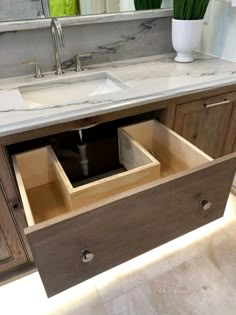 an open drawer in the middle of a bathroom sink