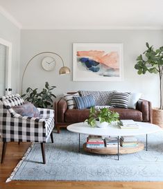 a living room with two couches and a coffee table in front of a painting on the wall