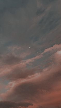 an airplane is flying in the sky at sunset or dawn with some clouds above it