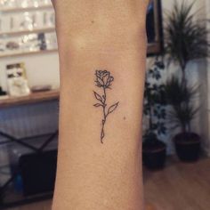 a single rose tattoo on the wrist