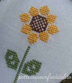 a cross stitch sunflower on a white background