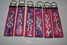 four key chains with letters and symbols on them