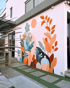 a large mural on the side of a building with plants and flowers painted on it