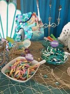 a table topped with lots of candy and candies on top of a cloth covered table