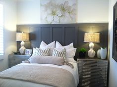 a bed with white and gray pillows in a bedroom