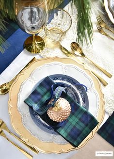 a place setting with plaid napkins and goldware