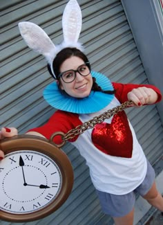 a woman in bunny ears holding a clock