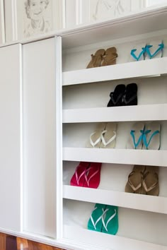 a white cabinet with several pairs of shoes on it's shelves in front of a wall