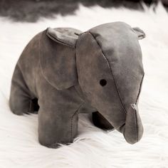 an elephant stuffed animal sitting on top of a white rug