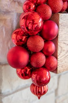 a bunch of red ornaments hanging from a brick wall