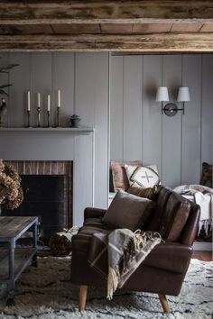 a living room filled with furniture and a fire place in front of a wall mounted clock