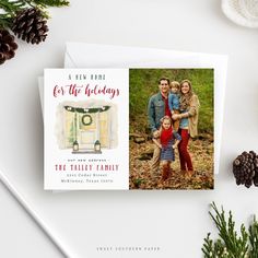 a holiday card with an image of a family and pine cones on the table next to it