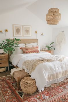 a bedroom with a bed, rugs and pictures on the wall above it is decorated in natural colors