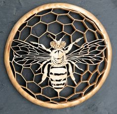 a bee carved into a piece of wood on top of a netted wall hanging