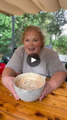 a woman sitting at a table with a bowl of food