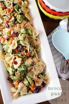 pasta salad with broccoli, raisins and cranberries on a white platter