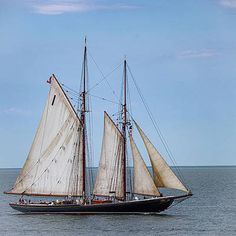 a sailboat sailing in the ocean on a sunny day