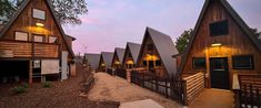 several wooden cabins with lights on at dusk