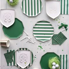 green and white plates with golf emblems on them next to eggs in a nest