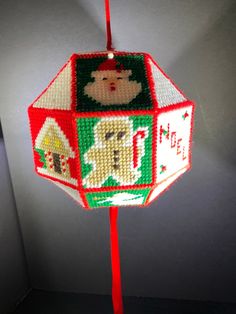 a christmas ornament hanging on a red pole in the corner of a room