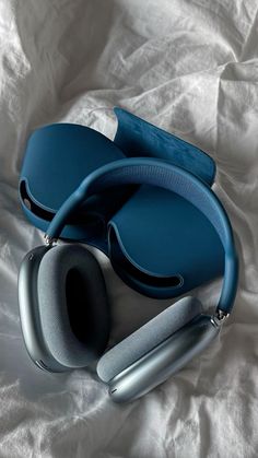 a pair of headphones laying on top of a white sheet with a blue case