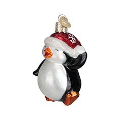 a glass penguin ornament wearing a santa hat