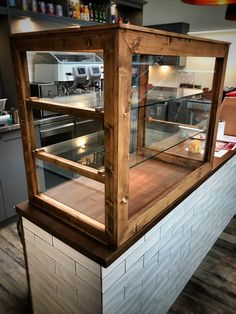 an empty counter in a restaurant with some food on it's shelves and lights hanging from the ceiling