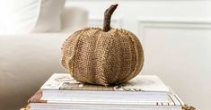 a burlap pumpkin sitting on top of some books