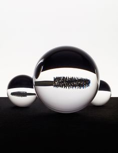 three balls with black and white designs sitting on top of each other in front of a white background