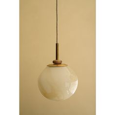 a white glass light hanging from a ceiling fixture with a wooden stick sticking out of it