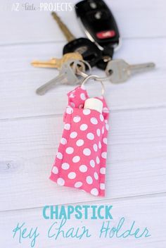 a pink polka dot keychain holder with two keys in it and the words, chapstick hey chap holder