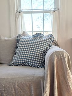 a couch with pillows on it in front of a window