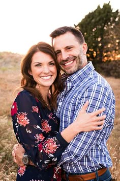 a man and woman hugging each other in a field