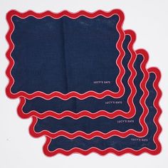 three pieces of cloth with red and blue designs on them, one in the shape of wavy lines