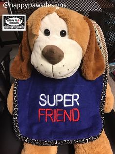 a stuffed dog wearing a blue shirt with the words super friend on it's chest