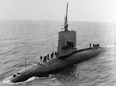 an old photo of a submarine in the water with people standing on it's side